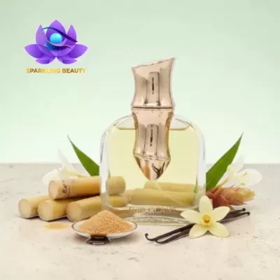 Frasco de perfume dourado com cana-de-açúcar e flores ao redor