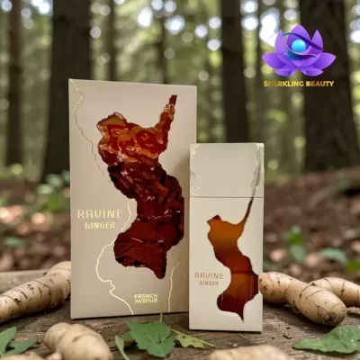 Frasco e caixa de perfume Ravine Ginger em tom creme com recortes translúcidos castanhos, texto dourado, sobre madeira com gengibre e folhas