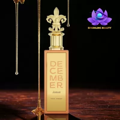 Frasco dourado de perfume DECEMBER ÁMBAR com líquido dourado viscoso ao lado