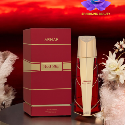 Perfume ARMAF Red Sky com embalagem vermelha e dourada sobre mesa redonda e flores