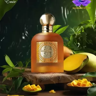 Frasco de perfume dourado com manga e folhas verdes em fundo escuro