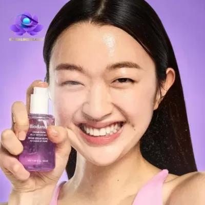 Mulher aplicando spray de sérum roxo no rosto com sorriso grande