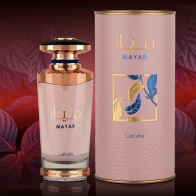 Frasco de perfume rosa com tampa dourada e embalagem rosa com detalhes em folhas