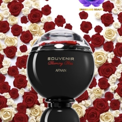 Frasco preto de perfume Souvenir Blooming Bliss Afnan com rosas vermelhas e brancas ao fundo