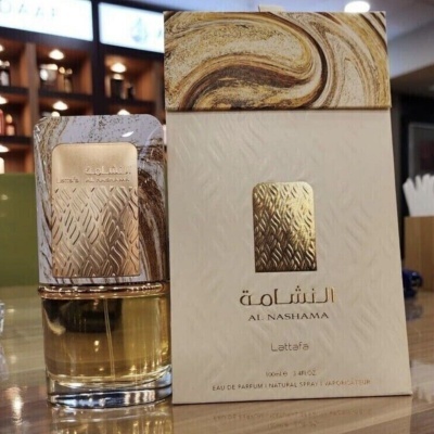 Perfume Al Nashama Lattafa, frasco em vidro com tampa dourada texturizada e caixa branca com detalhes dourados e marrons