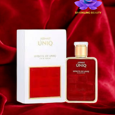 Perfume Armaf Uniq em frasco vermelho com tampa dourada e caixa branca com detalhe vermelho sobre tecido aveludado vermelho