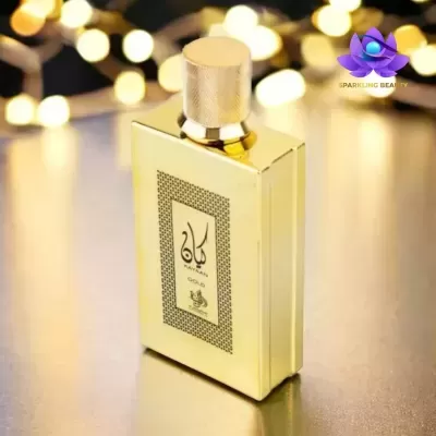 Frasco de perfume dourado com etiqueta árabe e luzes ao fundo