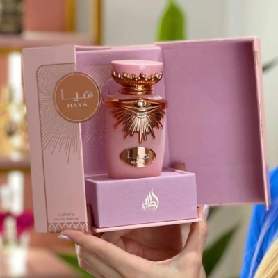 Frasco de perfume rosa e dourado numa caixa rosa aberta