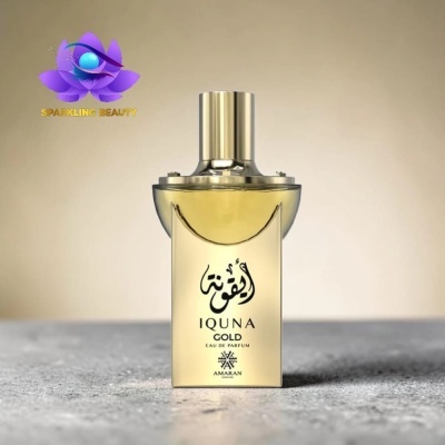 Frasco dourado de perfume IQUNA GOLD com tampa prateada sobre superfície cinza