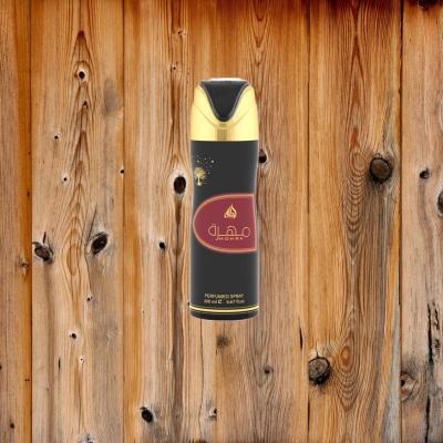 Frasco spray perfumado preto e dourado com etiqueta vermelha sobre fundo madeira