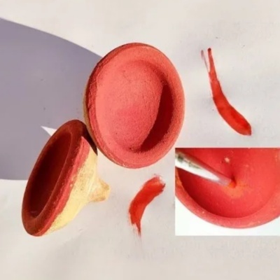 Duas ventosas de silicone vermelhas com pincel e manchas vermelhas sobre fundo branco