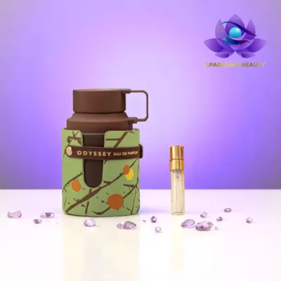 Frasco de perfume verde com padrão floral e estojo castanho ao lado de frasco pequeno transparente com tampa dourada sobre superfície branca e fundo roxo