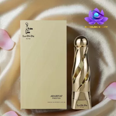 Frasco e caixa de perfume La-Di-Da ARABIYAT PRESTIGE sobre tecido cor de champanhe.