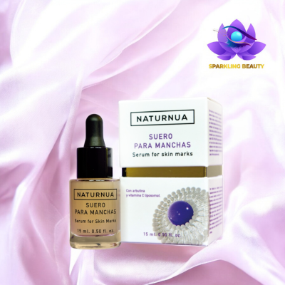 Frasco de serum para manchas NATURNUA e sua embalagem sobre tecido rosa claro.