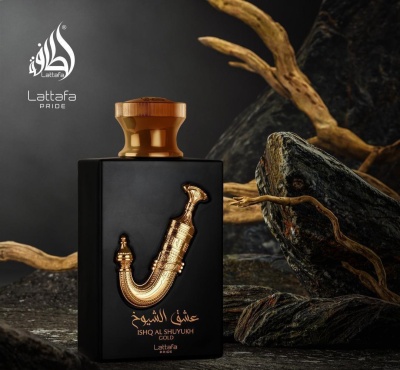 Frasco de perfume preto com decoração dourada e tampa castanha numa superfície rochosa