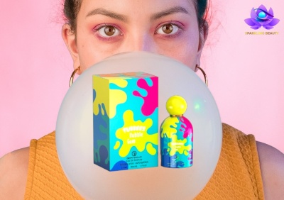 Frasco e embalagem colorida de perfume com padrão de manchas à frente de mulher com colete laranja