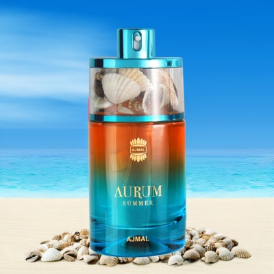 Frasco de perfume Ajmal Aurum Summer com tampa transparente e conchas, sobre areia e fundo de mar
