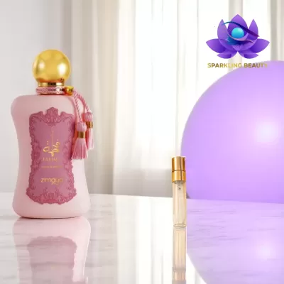 Frascos de perfume rosa e transparente sobre superfície branca com fundo claro e esfera roxa