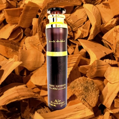 Frasco preto de purificador de ar com texto dourado sobre lascas de madeira castanha clara