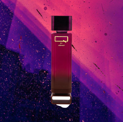 Frasco de perfume cor vinho Q BY ARMAF ESSENCE sobre fundo rosa e roxo