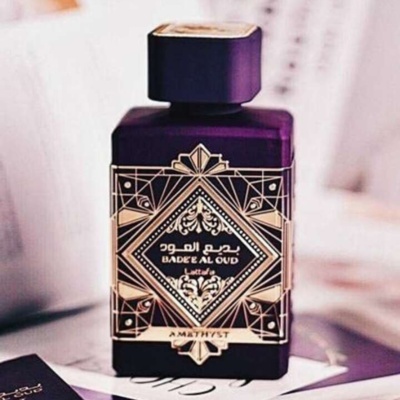 Frasco de perfume roxo com etiqueta dourada decorativa e texto