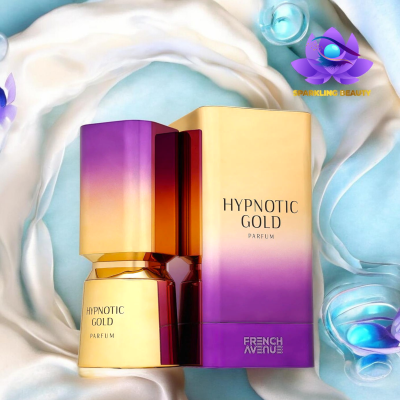 Frasco de perfume dourado e roxo com caixa em gradiente de dourado para roxo com texto Hypnotic Gold Parfum e French Avenue, sobre tecido branco e azul com pétalas e vidro.