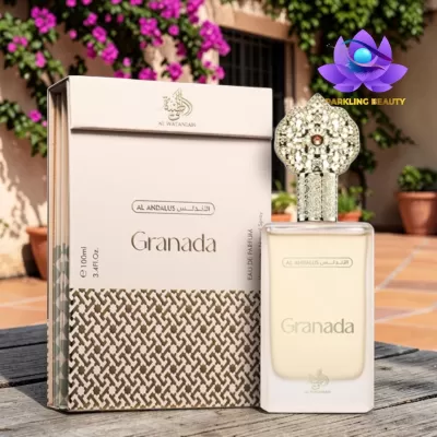 Frasco de perfume Granada com embalagem e tampa dourada em ambiente exterior com flores.