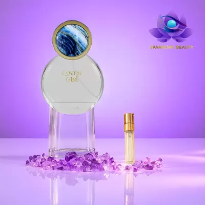 Frasco de perfume Cover Girl com pequeno frasco spray e cristais roxos num fundo lilás