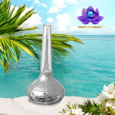 Frasco cosmético prateado com tampa translúcida junto ao mar e flores brancas