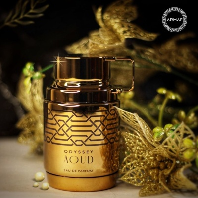 Frasco dourado de perfume Odyssey Aoud com padrão geométrico preto e decoração dourada ao fundo