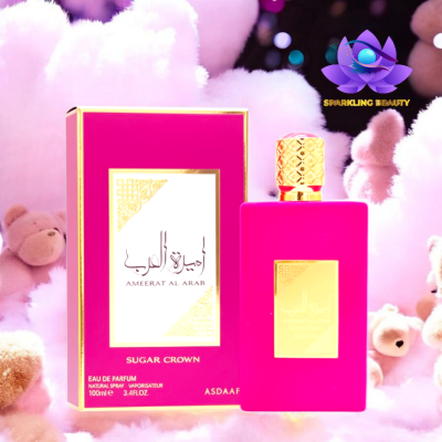 Perfume rosa com embalagem dourada e caixa a condizer em fundo com peluches cor-de-rosa