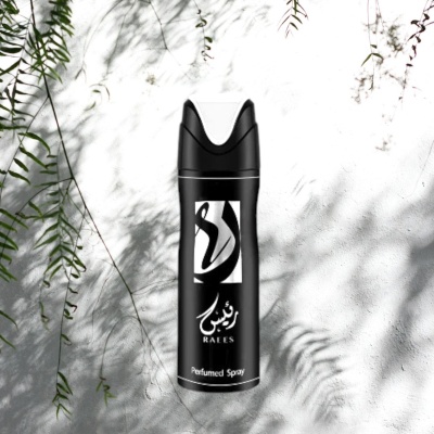 Frasco preto de spray perfumado Raees com texto árabe, sobre fundo branco e sombras de folhas