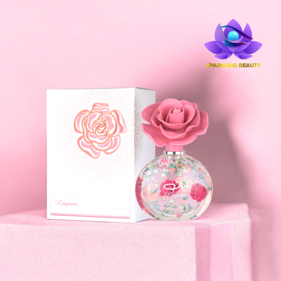 Perfume com tampa de flor cor de rosa e caixa branca com desenho de rosa