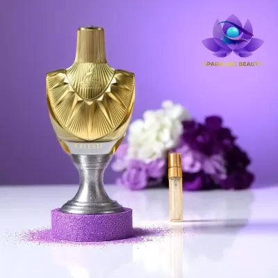Frasco de perfume dourado sobre pedestal com espuma roxa e flores ao fundo