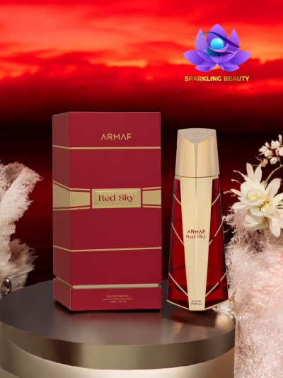 Perfume ARMAF Red Sky com embalagem vermelha e dourada sobre mesa redonda e flores