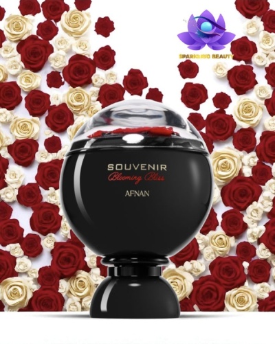 Frasco preto de perfume Souvenir Blooming Bliss Afnan com rosas vermelhas e brancas ao fundo
