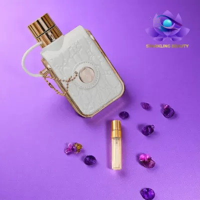 Frasco de perfume branco com tampa dourada e pedras decorativas sobre fundo roxo