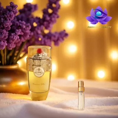 Frascos de perfume sobre superfície branca com flores roxas e luzes ao fundo