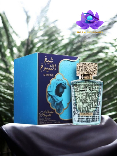 Frasco de perfume transparente com tampa dourada ao lado de caixa azul com detalhes dourados e imagem de homem árabe.