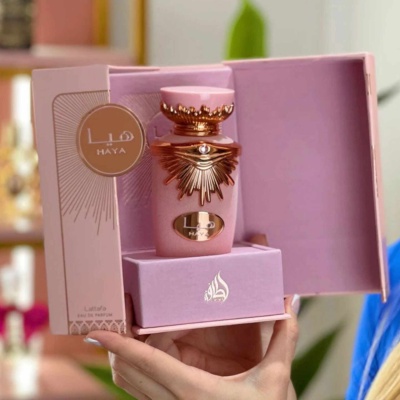 Frasco de perfume rosa e dourado numa caixa rosa aberta