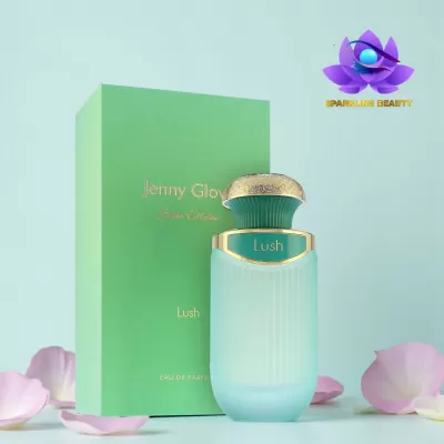 Frasco de perfume azul claro fosco com tampa dourada e caixa verde com texto dourado rodeado por pétalas de flores