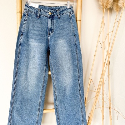 Calças de ganga azuis penduradas em cabide de madeira