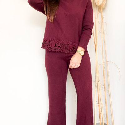 Conjunto de malha vinho com decorações em renda floral na parte inferior da camisola e calças.