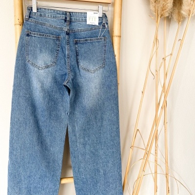 Calças de ganga azuis de corte direito penduradas com etiqueta