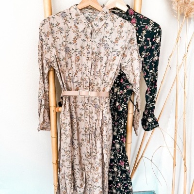 Vestidos compridos de manga comprida com padrão floral pendurados em suporte de bambu