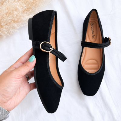 Sapatos boneca pretos com fivela dourada sobre fundo branco