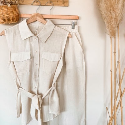 Conjunto de roupa bege em tecido leve pendurado com blusa sem mangas e calças com cós elástico