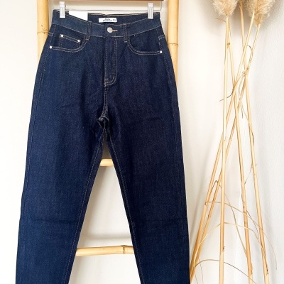 Calças de ganga azuis escuras penduradas numa estrutura de bambu