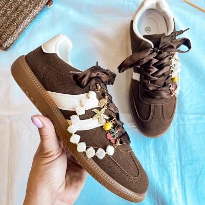 Sapatilhas castanhas com solas de borracha e atacadores decorados com pendentes