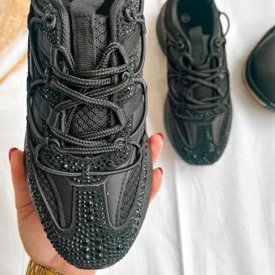Ténis pretos com pedras brilhantes e atacadores grossos